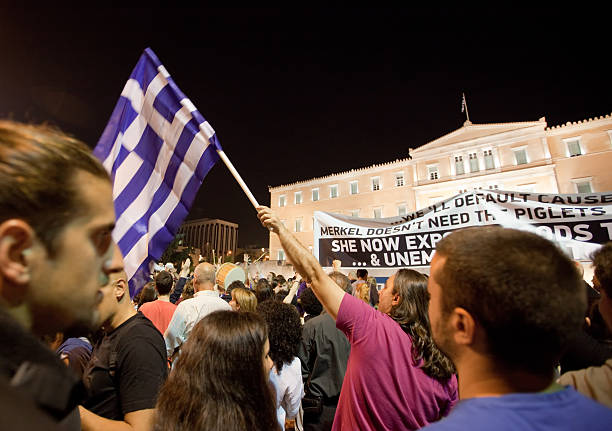 Greek 'Indignant' protests in Syntagma square "Athens, Greece - May, 28th 2011:  Although it is almost midnight, hundreds of people of all ages are gathered in Syntagma Square. They are the \'Indignant\' citizens and demonstrate against the austerity measures announced by the government. This is the fourth consecutive day they gather in front of the Greek Parliament. The protests were organized via Facebook, Twitter and other social media, without the involvement of political parties or trade unions, and were inspired by Spain\'s \'Los Indignados\' movement. Very high ISO used to capture the scene." budget cut stock pictures, royalty-free photos & images