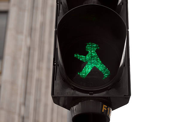 Green - go! "Berlin, Germany - May 29, 2011: Typical and famous pedestrian traffic light of Berlin with walking green man \""AmpelmAnnchen\"", so called \""Berliner AmpelmAnnchen\"". Pedestrian light is made by German technology company Siemens (see bottom left of light)." ampelmännchen photos stock pictures, royalty-free photos & images