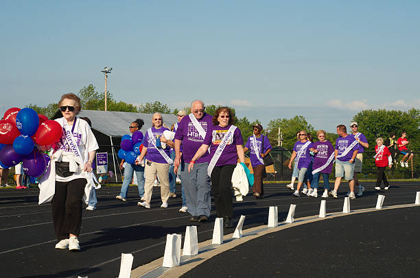 Survivor walk "Twinsburg, Ohio - June 5, 2009: Cancer survivors walk the first lap of Relay for Life, an annual two-day fund-raising event sponsored by the American Cancer Society, held on June 5-6, 2009, in Twinsburg." walking for a cause stock pictures, royalty-free photos & images