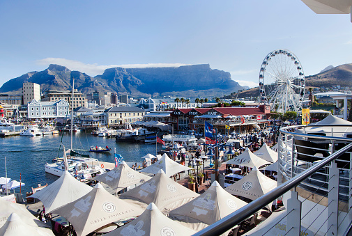 Cape Town, South Africa - December, 31st 2011: Victoria &amp; Alfred Waterfront in Cape Town, a major tourist attraction, with restaurants, hotels and a shopping mall. Table Mountain is seen in the background.