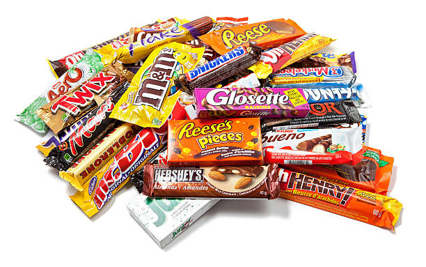 Heap of Assorted Chocolate Products "Toronto, Canada - May 8, 2012: This is a studio shot of a variety of chocolate products made by various companies including Nestle, Hershey's, Mars Inc., Cadbury and Ferrero SpA isolated on a white background." cadbury plc photos stock pictures, royalty-free photos & images