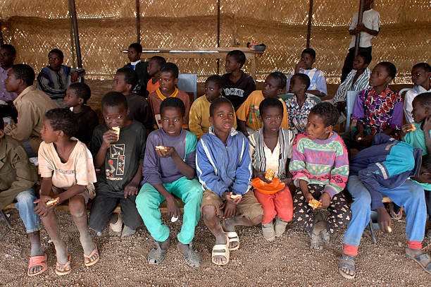 african children "Burkiana Faso, Ouagadougou. February  22, 2005: Orphans in the orphanage in the capital of Burkina Faso Ouagadougou. A few kilometers from the capital Ouagadougou is located Loumbila orphanage. A structure that houses 150 children without families, most of them come from households too poor to support even the mere cost of one meal a day, or children who have lost their parents because of \'AIDS" orphan stock pictures, royalty-free photos & images