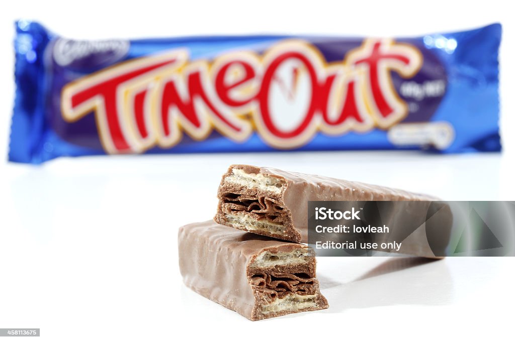 Cadbury Timout Chocolate bar snack "Penrith, Australia - 25 February, 2011: Cadbury Timout chocolate bar 40g (892kj)  Showing wrapper in background and chocolate contents in focus in the foreground.   Timeout consists of wafer biscuits with a flake chocolate centre and coated in milk chocolate.  Photographed in studio on a white background." Candy Wrapper Stock Photo