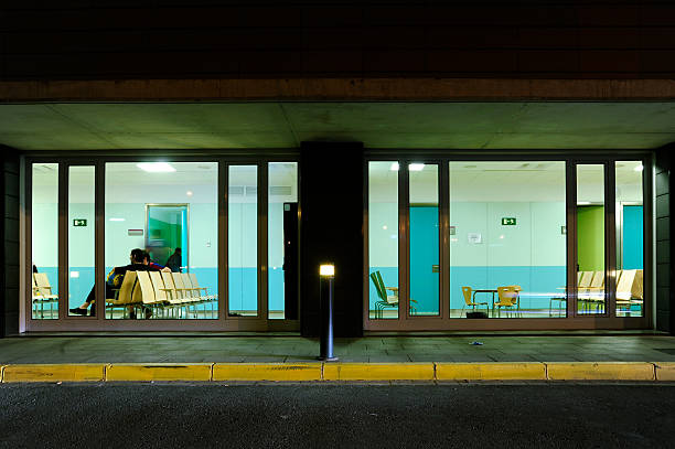 Public building at night "Lleida, Spain - May 20, 2010:Few people waiting in the emergency room of the Hospital Arnau de Vilanova in Lleida. Vison from Experior on the street" unknown gender stock pictures, royalty-free photos & images