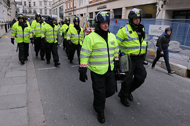 Riot Police in London "London, UK - March 26, 2011: Police in riot gear advance through central London during a large anti-cuts rally on March 26, 2011 in London, UK." riot police stock pictures, royalty-free photos & images