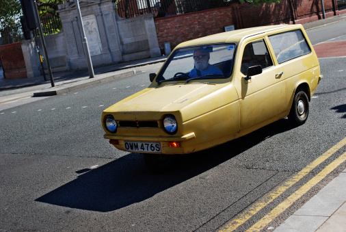 Liverpool, England - September 13, 2009: Man driving a yellow Reliant Robin three-wheel car in Princes Road, Liverpool.