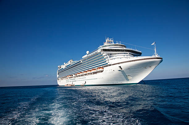 Cruise Ship in Caribbean Sea "Eastern Caribbean Sea - February 8, 2010:  A luxury cruise ship anchors in the water as passengers are taken by ferry to the local tropical island for a day of sun and fun." cruising stock pictures, royalty-free photos & images