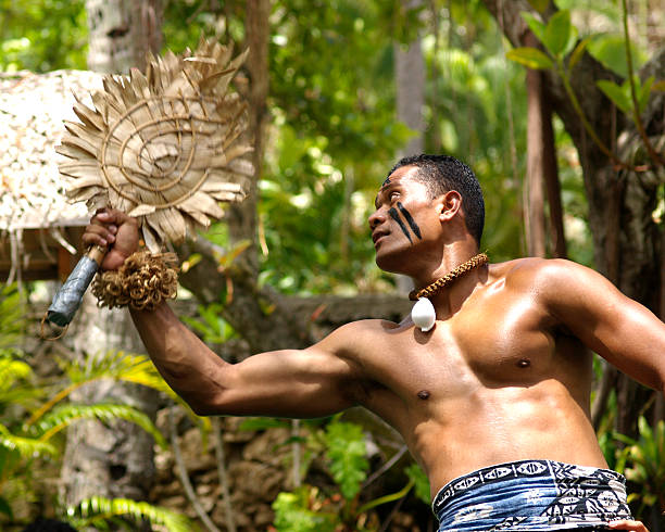 Fijian Dancer "Oahu, Hawaii, USA aa July 5, 2006: A dancer dressed as a Fijian warrior performs at the Polynesian Cultural Center. Operated by Brigham Young University, the living museum features the cultures of Hawaii, Samoa, New Zealand, Fiji, Tahiti, Tonga, and the Marquesas Islands." fiji stock pictures, royalty-free photos & images