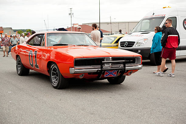 1969 Dodge Charger General Lee "Dartmouth, Nova Scotia Canada - June 14, 2012: Front end of a 1969 Dodge Charger classic car driving in a parking lot outside in Dartmouth, Nova Scotia, Canada.  This Charger has been painted to match the General Lee car from the old television series The Dukes Of Hazzard.  People can be seen looking at the car as the driver passes by them" the general lee stock pictures, royalty-free photos & images