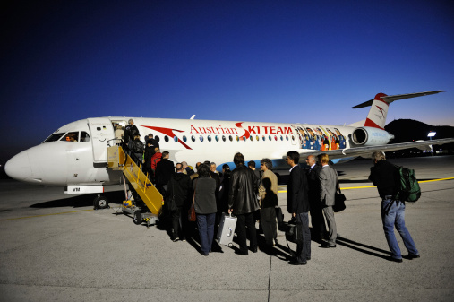 Salzburg, Austria - September 17, 2012: Passengers boarding an Austrian Airlines Fokker 100 aircraft for the early morning flight LH 1109 from Salzburg to Frankfurt am Main. The aircraft's livery is showing famous Austrian skiers. Austrian Airlines is a subsidiary of Deutsche Lufthansa AG.