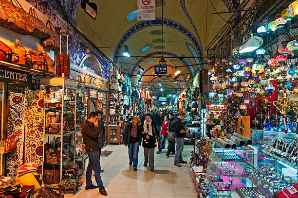Tourists in the grand Bazaar, Istanbul. Istanbul, Turkey - January 24, 2011: Tourists in shopping at The Grand Bazaar in Istanbul, one of the oldest and largest covered markets in the world. The Grand Bazaar opened in 1461, and now have more then 4000 shops. grand bazaar istanbul stock pictures, royalty-free photos & images