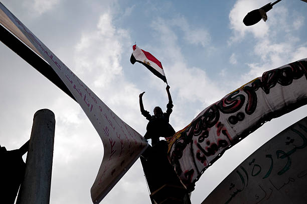egyptian obrót człowiek z flagą przeciwko niebo - egypt revolution protest egyptian culture zdjęcia i obrazy z banku zdjęć