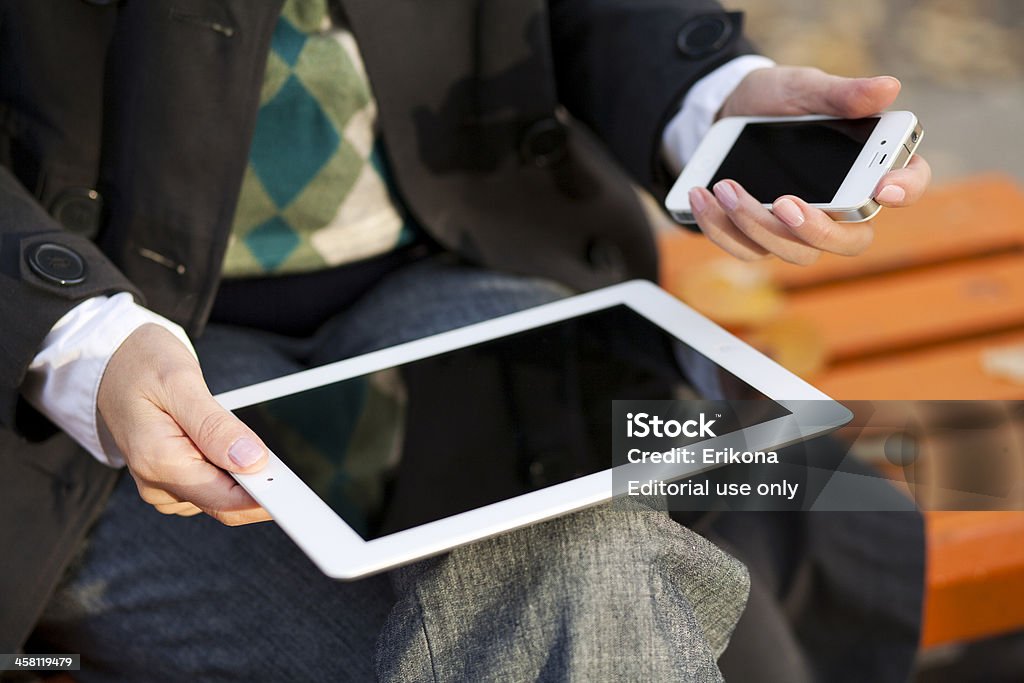 Donna utilizzando iPad e iPhone - Foto stock royalty-free di Adulto