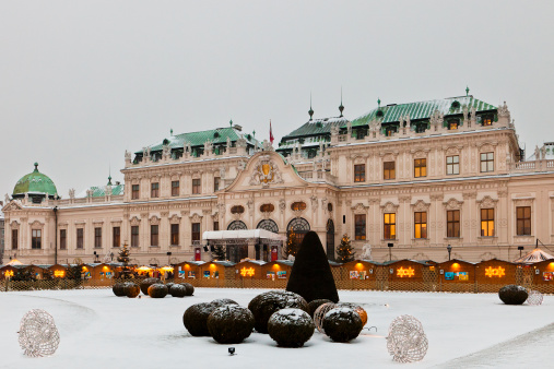 Vienna, Austria - December 14, 2010: It's a snowy and cold afternoon at the Belvedere Palace, where every year a tiny Christmas Village is held, set against a beautiful  baroque backdrop. This is one of the most beautiful sights of Vienna.