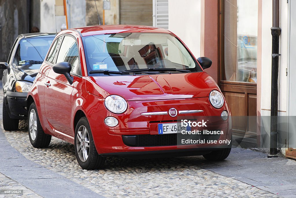 Red Fiat 500 parked in the street Varallo Sesia, Italy - August 1, 2011: Red Fiat 500 parked in the street in Varallo Sesia, Piedmont, Italy. Fiat S.p.A. is an Italian automobile manufacturer, engine manufacturer, financial and industrial group based in Turin in the Piedmont region. Architecture Stock Photo