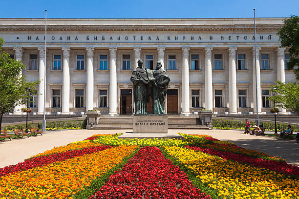 Bulgarian National Library "Sofia, Bulgaria aA June 29, 2012: The National Library in the capital of Bulgaria, Sofia, with a beautiful flower carpet and a statue of the inventors of the cyrillic alphabet. People visible in the image." bulgarian culture photos stock pictures, royalty-free photos & images
