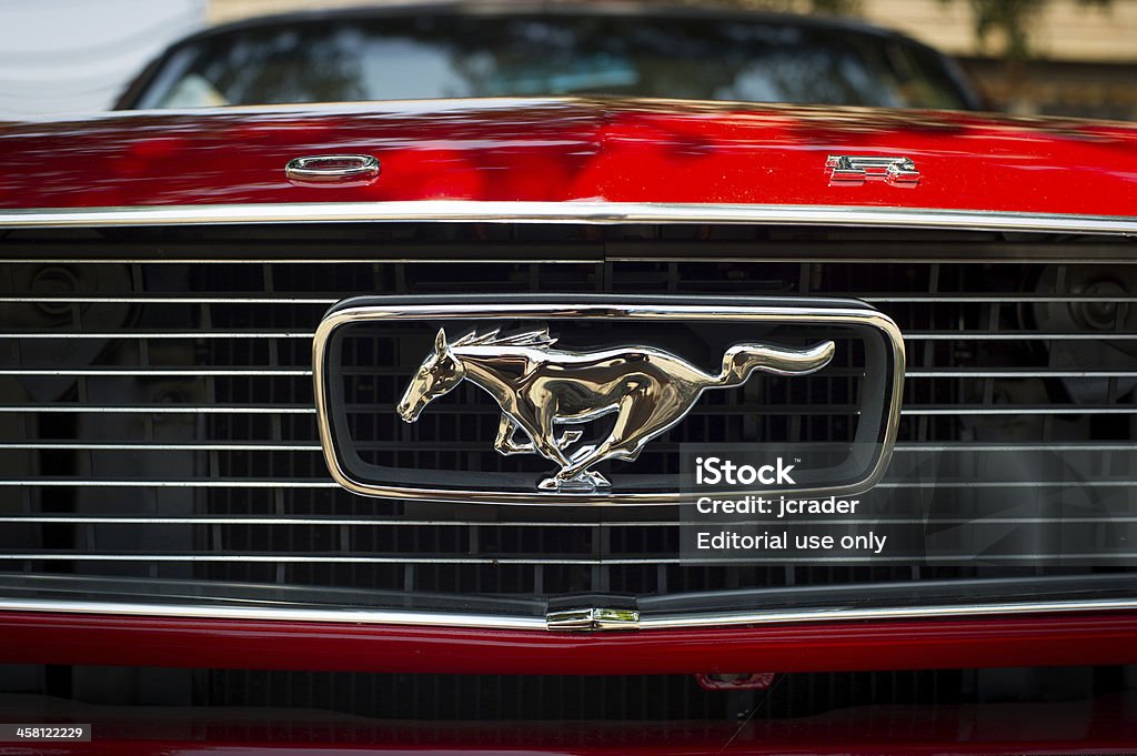Red Ford Mustang logo on front car "Magnolia, Arkansas, USA - May 19, 2012: Ford red Mustang horse logo on front of car at the 24th annual Magnolia Blossom Festival" Ford Mustang Stock Photo