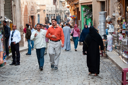 Cairo, Egypt - March 28, 2010: Egyptians walk along Al-Muizz li-Din Allah, a pedestrian street in Islamic Cairo beside the Khan el-Khalili bazaar. This area is also known as Islamic Cairo since it was the heart of medieval Cairo and contains many Islamic architectural treasures.