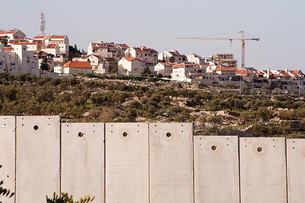 Israeli separation wall and settlement "Bethlehem, Occupied Palestinian Territories - March 10, 2012: Construction cranes work to expand the Israeli settlement of Gilo, considered illegal under international law as it is built on occupied Palestinian territory, but separated from the neighboring West Bank town of Bethlehem by the Israeli separation wall." bethlehem west bank stock pictures, royalty-free photos & images