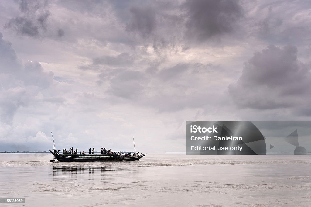 Ferry boat, on route to Majuli Island, Assam, India "Jorhat, India - August 23, 2011: A view of the ferry boat that shunts between the island of Majuli and Jorhat, both in Assam. The ferry in this shot, full of people, is travelling to Jorhat across the river Brahmaputra. A storm is brewing and the river is high from the monsoon rains." Asia Stock Photo