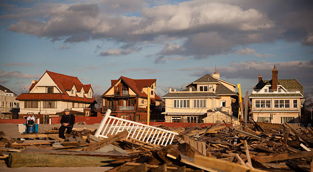 New York City, USA - December 11, 2012: Old man sitting between ruins at Brighton Beach, Brooklyn. Parts of a ruined homes still on the Brighton Beach as a consequences of the Sandy hurricane after about 2 month after hurricane.