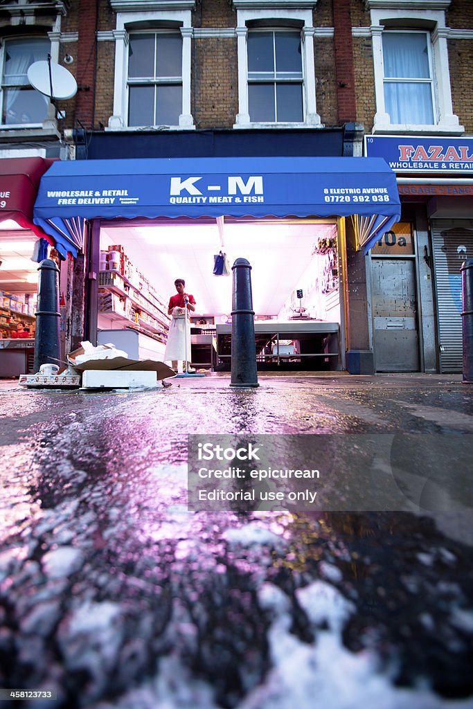 Brixton market butcher shop at closing time "London, UK - May 4, 2011: Employees of a butcher shop in the colorful Brixton market in London mop the floors and prepare to close down for the night." British Culture Stock Photo