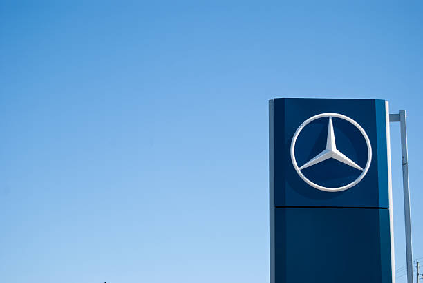 Mercedez-Benz Dealership Sign Against Clear Sky "Halifax, Nova Scotia Canada - March 27, 2011: A photograph of a large Mercedes-Benz dealership sign at a car dealership in Halifax, Nova Scotia, Canada.  The business sign contains the large iconic Mercedes-Benz 3 point star logo" mercedes benz photos stock pictures, royalty-free photos & images