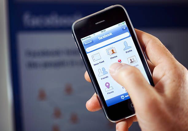 facebook-anwendung auf dem apple iphone - men iphone internet social networking stock-fotos und bilder