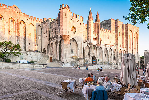 Saint Emilion, France --April 6, 2015: People are eating at the restaurants on the square in front of Saint-Emilion Monolithic Church, one of the main landmarks in the city.