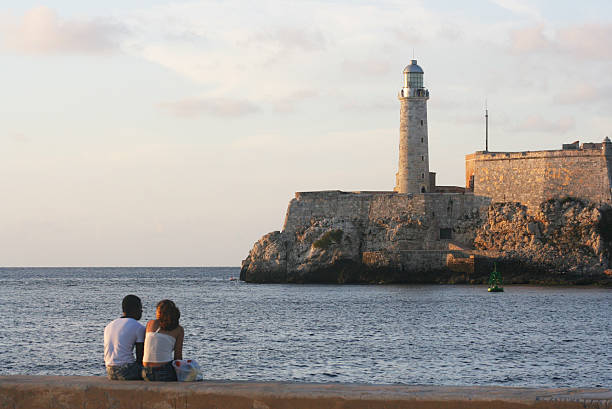 Lovers at the Havana Harbor "Havana, Cuba - March 29, 2007. Lovers sit at the Havana harbor enjoying the beautiful sunset of the city and their leisure moment." havana harbor photos stock pictures, royalty-free photos & images