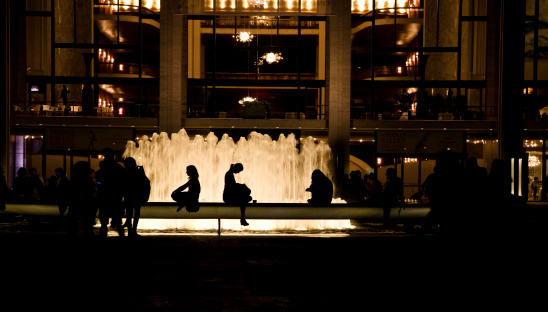 New York, United States - July 1, 2011: Silhouette of people in front of the Lincoln Center for the Performing Arts fountain