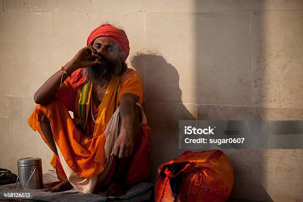 Holy Man In Orange Robes Smoking Stock Photo - Download Image Now - Accessibility, Adult, Brahmin