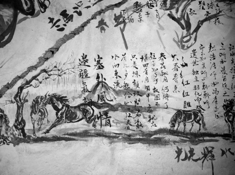 Nanjing,China - July 16,2011:horse graffiti on the dilapidated wall of waste building.some Chinese classical poems and ink drawing horses.