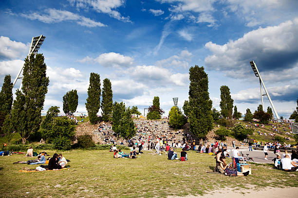 Sunday at Mauerpark Berlin Germany "Berlin, Germany - June 10th, 2012: Spring Sunday afternoon at Mauerpark in east Berlin. The path and lawn are full with groups of mainly young adults, enjoying their free day at the calm park and engaging in various activities." mauer park stock pictures, royalty-free photos & images