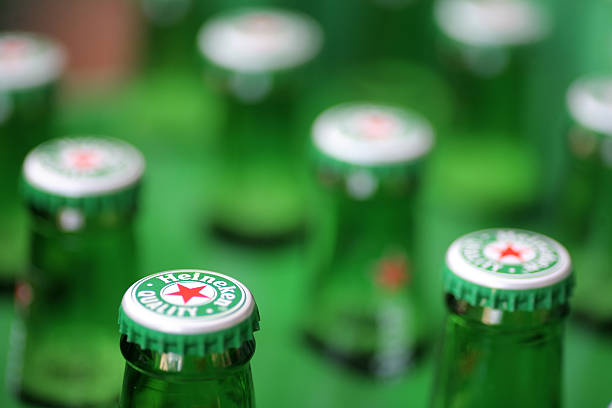 Heineken beer "Bucharest, Romania - July 26, 2011: Close-up shot of a Heineken beer bottle caps. Heineken is a Dutch beer which has been brewed by Heineken International since 1873." opening bottle cap photos stock pictures, royalty-free photos & images