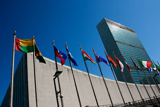 siège des nations unies et agitant des drapeaux en l'état de new york, états-unis - siège des nations unies photos et images de collection