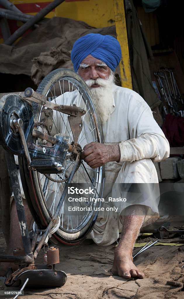 Hombre viejo Sikh es reparar el ciclo - Foto de stock de Adulto libre de derechos