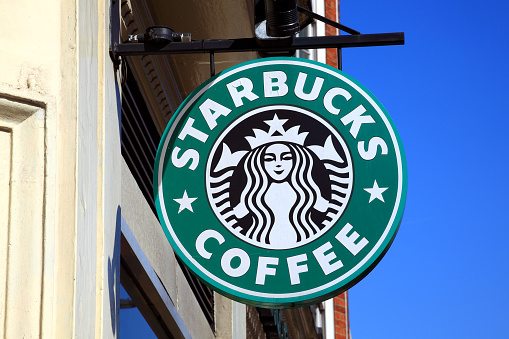 London, United Kingdom - April 9, 2011: Starbucks green logo advertising sign hanging outside one of its coffee houses