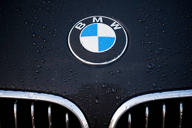 BMW "Padua, Italy - July 6, 2011: Circle shape BMW logo and part of the front grill on a black car covered with dew drops. BMW (Bayerische Motoren Werke) is a German automobile, motorcycle and engine manufacturing company founded in 1916." bmw stock pictures, royalty-free photos & images