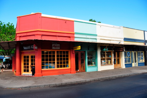 Lahaina, HI, United States - July 14, 2012: Facades of colourful tourist stores in the heart of Lahaina's tourist district. The red store in the foreground is a shaved ice store. 