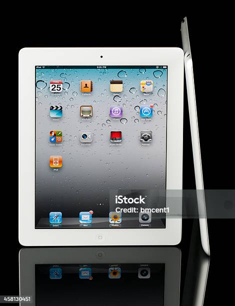 Two Apple Ipad 2 Tablets Isolated On Reflective Black Surface Stock Photo - Download Image Now