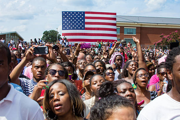College Students Gather at Barack Obama 2012 Campaign Rally Norfolk, VA, USA - September 4th, 2012: Students cheer and take photos on their cell phones at the 2012 Barack Obama Presidential Campaign Rally at Norfolk State University, a historically black university.  political rally photos stock pictures, royalty-free photos & images