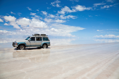 BOLIVIAN ALTIPLANO, BOLIVIA - March 02, 2011: 4x4 crossing the Salar de Uyuni, Bolivia. people doing a trek in high altitude in a Toyota Land Cruser 1999.  Toyota is a multinational automaker headquartered in Toyota, Aichi, Japan.