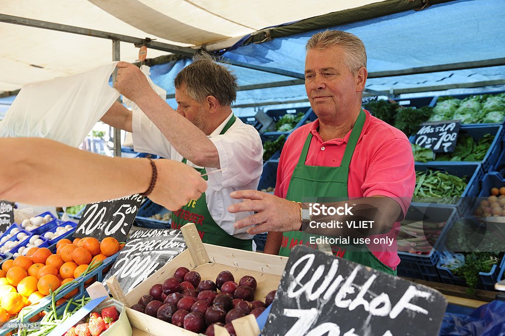 Dois greengrocers ao ar livre em um mercado movimentado de holandês - Foto de stock de Moeda Corrente royalty-free