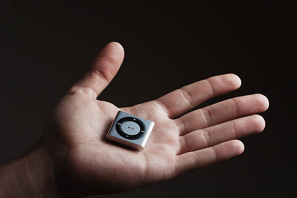 apple ipod shuffle en la mano - ipod shuffle fotografías e imágenes de stock