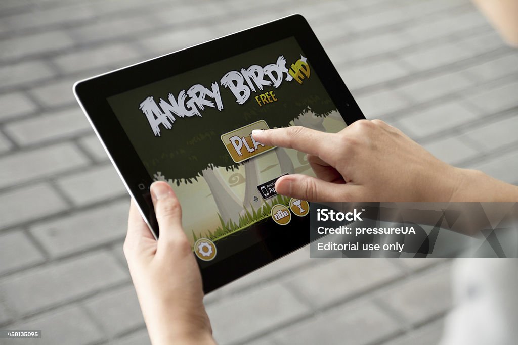 Play Angry Birds on Apple Ipad2 "Kiev, Ukraine - July 31, 2011: A woman outdoors play in the game Angry Birds on Apple Ipad2. This second generation Ipad2 is designed and development by Apple inc. and launched in march 2011. Angry Birds is most popular game, developed by Rovio Mobile studio." Angry Birds - Game Stock Photo