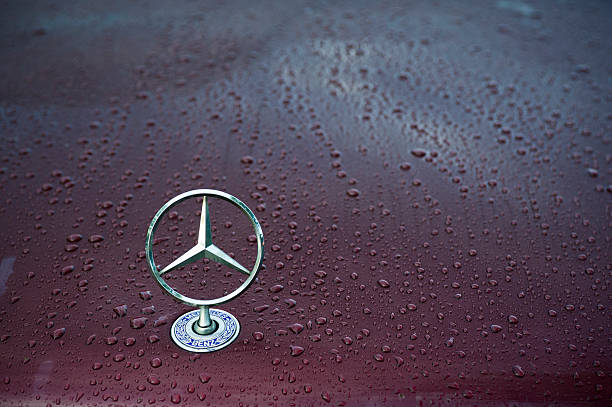 Mercedes logo "Padua, Italy - July 6, 2011: Mercedes classical logo on a wet car hood. Mercedes-Benz, a division of Daimler AG, is a German manufacturer of automobiles, buses, coaches, and trucks. The name traces its origins to Daimler 1901 Mercedes and to Karl Benz 1886 Benz Patent Motorwagen, widely regarded as the first automobile. Mercedes today is synonymous with luxury, sportiness and technical reliability. Shot in a public parking." mercedes benz photos stock pictures, royalty-free photos & images