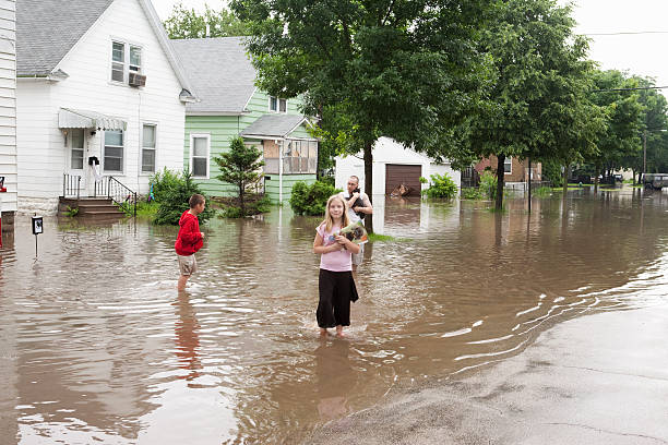 Midwest Flood Victims "Cedar Rapids, IA,USA - June 12, 2008: A family evacuates a flooded home during The flood in Cedar Rapids,IA, 2008." walking in water stock pictures, royalty-free photos & images