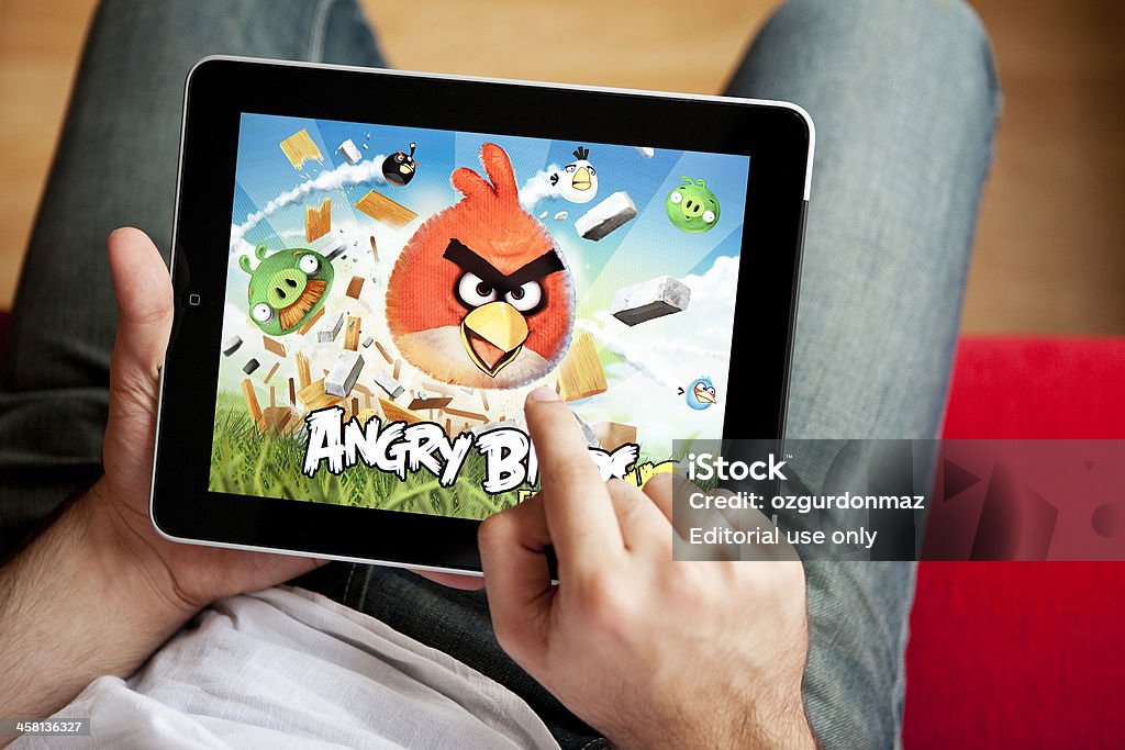 Hombre jugando con Angry Birds on Apple iPad un - Foto de stock de Juegos libre de derechos