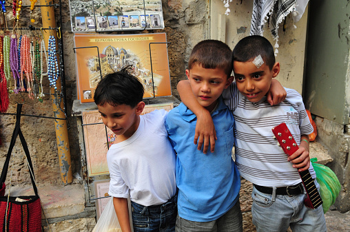 Jerusalem, Israel - October 18, 2010: Palestinian boys hang out in the Christian Quarter of the Old City. Israel annexed the Old City and the rest of East Jerusalem shortly after the Six-Day War in 1967, but  few countries have officially recognized the annexation.
